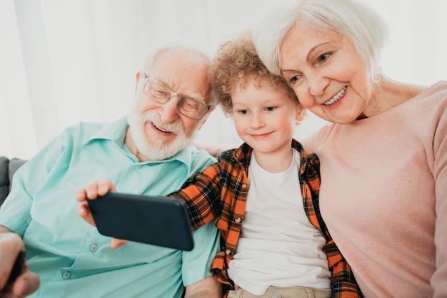 Abuelos y nieto jugando en casa - Familia en casa, abuela y abuelo cuidando sobrino