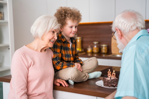 Abuelos y nieto jugando en casa - Familia en casa, abuela y abuelo cuidando sobrino