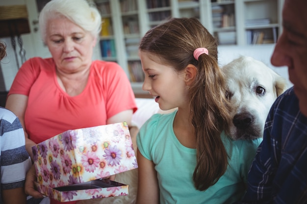 Foto abuelos y nietos mirando regalo sorpresa en la sala de estar