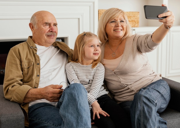 Foto abuelos y niños de tiro medio tomando selfie