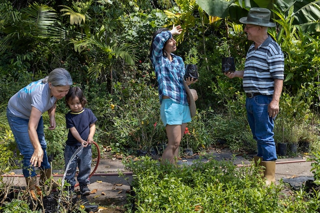 Abuelos con su hija y nieto latinoamericano trabajan en su jardín