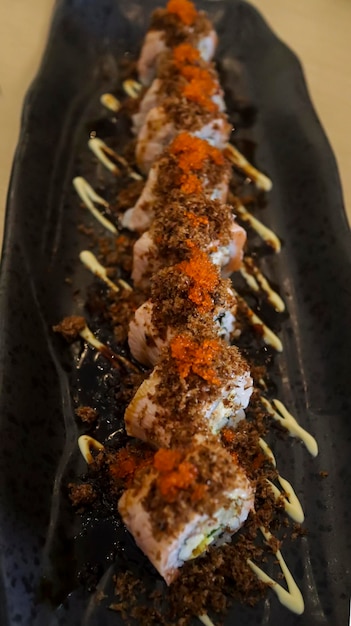 Foto aburi salmon roll consiste em carne de caranguejo com arroz de sushi de caranguejo de casca mole e enrolado depois disso, o topo é dado aburi que é carne de peixe grelhada que vem de uma combinação de salmão e atum