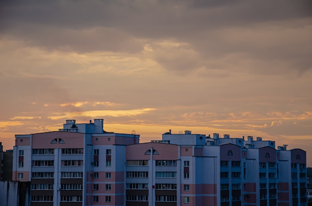 Aburridas casas de varios pisos de una ciudad moderna en el fondo del atardecer