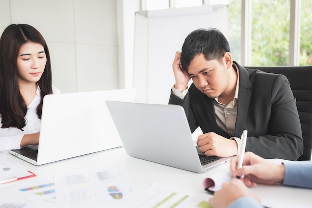 Aburrido y estresante reunión del equipo de negocios asiáticos