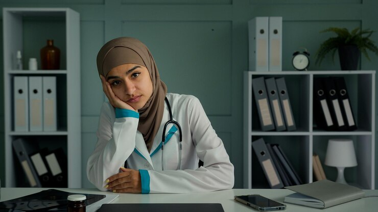 Foto aburrido infeliz mujer pensativa médico musulmán interno sentarse en la clínica de oficina sentir tristeza desesperación