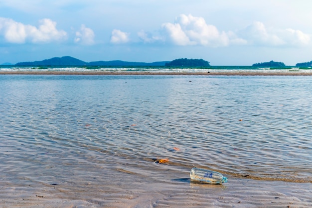 Foto abwasserflaschen, die auf der strandseite schwimmen, umweltverschmutzungsprobleme von menschen.