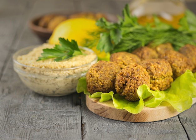 Acabado de fazer falafel em uma tábua com molho tahina e ervas e limão