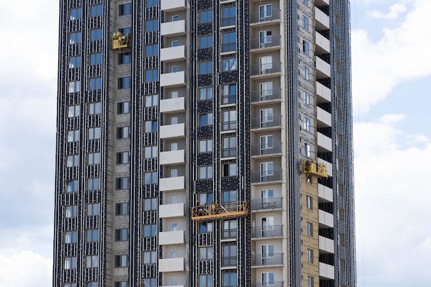 Acabamento de edifício residencial em construção com placas de isolamento térmico.