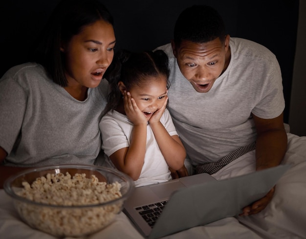 Foto ¿acabas de ver esa foto de una pareja joven sentada en la cama con su hija y usando una computadora portátil por la noche?