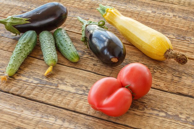 Acabo de recoger tomates pepino berenjenas y calabaza en viejas tablas de madera Vista superior