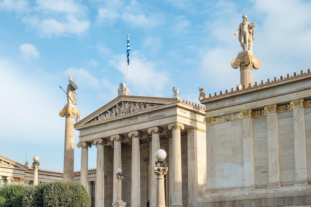 Foto academia de atenas com coluna de mármore com esculturas de apolo e atena em atenas, grécia popular