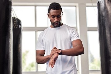 Homem negro de relógio inteligente e exercício para fitness com tela de  maquete para verificar o desempenho do tempo mãos do esportista com  aplicativo de saúde smartwatch para passos cardíacos e relógio