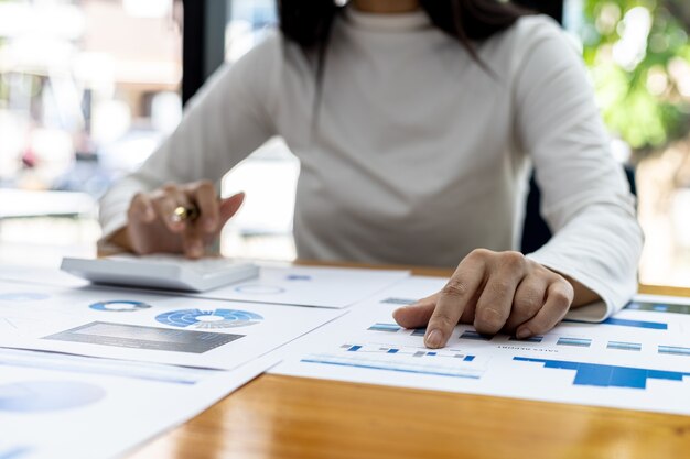 Foto una académica financiera apunta a un documento con un bolígrafo, analiza y verifica la precisión de los datos financieros de la empresa antes de presentarlos a la reunión. concepto de auditoría financiera.