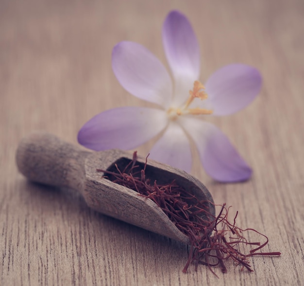 Açafrão em uma concha de madeira com flor de açafrão