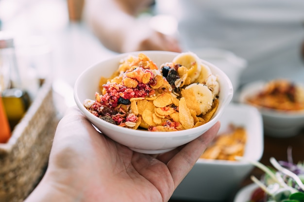 Foto acai bowl mix mit frischer mango, avocado, banane, beeren, sonnenblumenkernen, chiasamen und müsli.