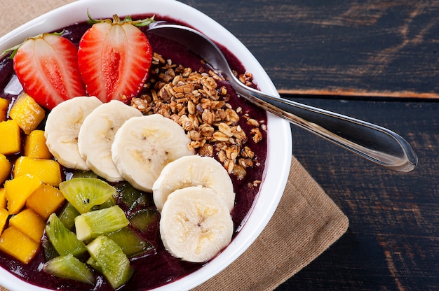 Açaí brasileiro em uma tigela acompanhado de frutas tropicais. fruta da amazônia