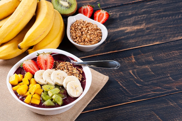 Açaí brasileño en un bol acompañado de frutas tropicales. Fruta del Amazonas