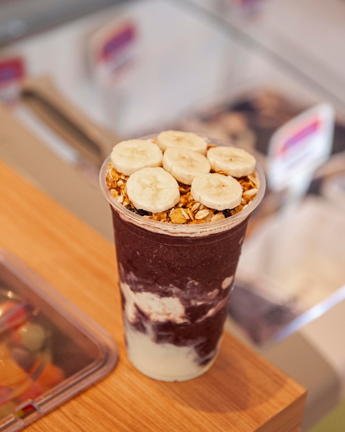 Acai-Eisbecher mit Banane und Müsli auf der Eistheke Platz kopieren