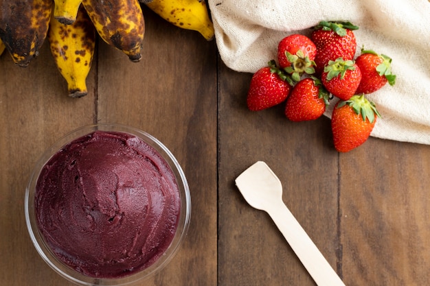 Acai, tazón de helado brasileño de baya de Acai congelada. con frutas en mesa de madera. Vista superior del menú de verano