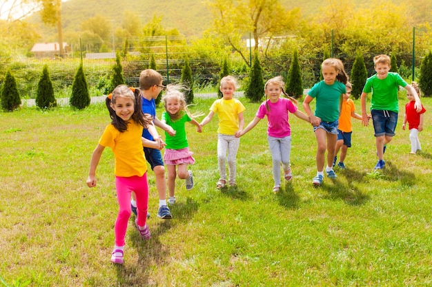 Acampamento de verão infantil jogos ativos ao ar livre, crianças vestindo camisetas coloridas