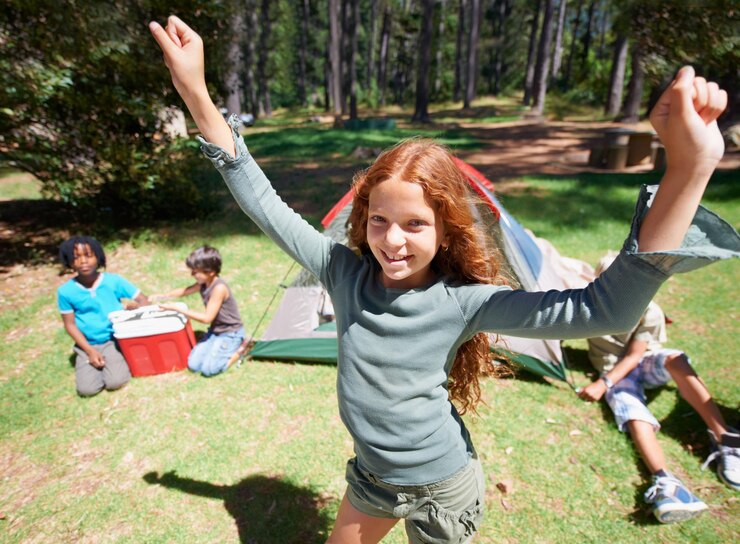 Foto acampamento excitado ou retrato de menina na natureza para jogar aventura ou férias de férias no parque relaxar as mãos para cima ou criança jovem feliz com sorriso no bosque jardim ou floresta para jogos divertidos ou infância