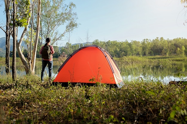 Acampando em uma floresta. cena da manhã com tenda turística na floresta verde perto do lago