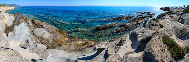 Acampar na costa rochosa de sithonia de manhã de verão (calcidice, grécia). panorama de pontos de três tiros. pessoas e carros em camping irreconhecíveis.