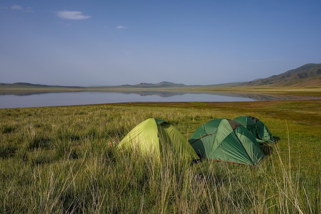 acampar na natureza à beira do lago na grama