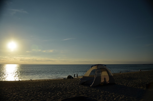 Acampar na praia ao pôr do sol