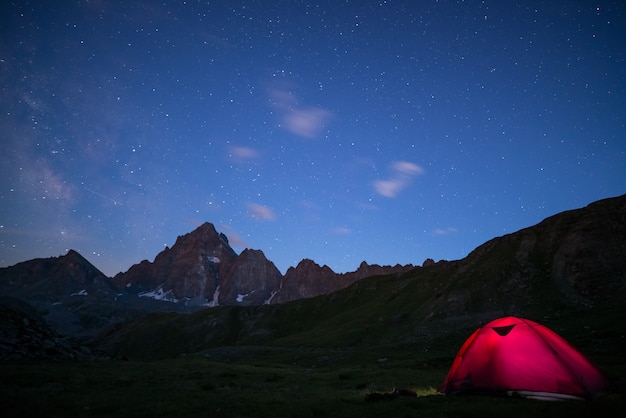 Acampar sob o céu estrelado e a via látea na alta altitude nos alpes.