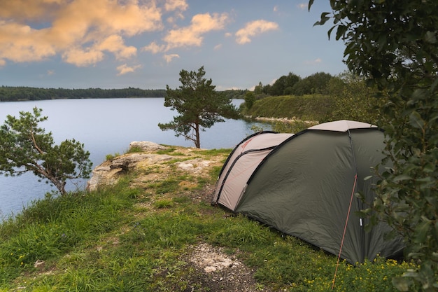 Acampar con una tienda en la naturaleza en la orilla del lago Rummu en verano