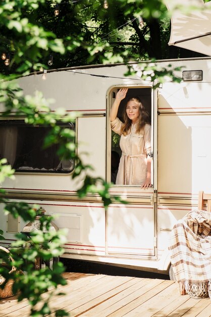 Foto acampar y viajar persona feliz relajándose al aire libre cerca del remolque mujer está lista para el viaje por carretera