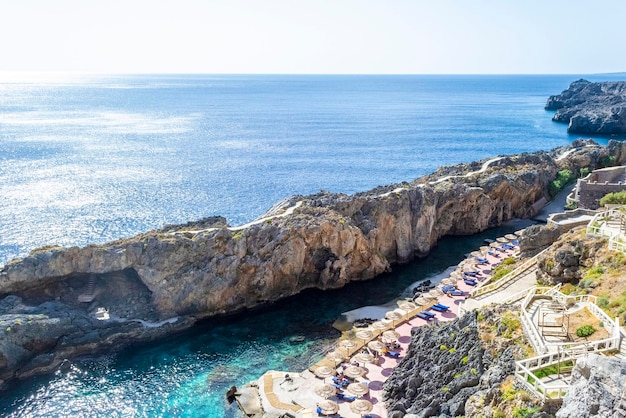 Acantilado junto al mar y la bahía con sombrillas, Creta, Grecia