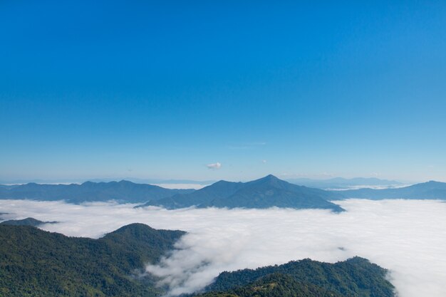 Acantilado en el valle y montañas con niebla a la luz del día