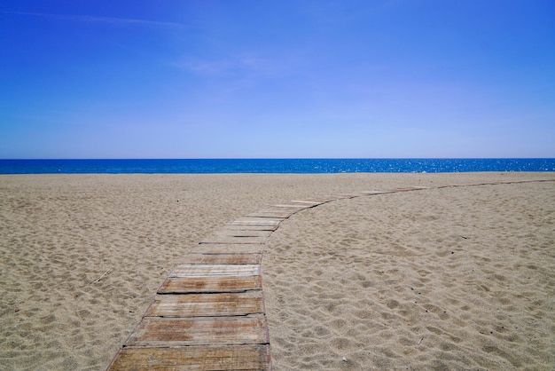 Acceso de camino de madera en playa de arena en el océano atlántico en la costa de lacanau en francia