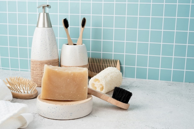 Accesorios de baño con cepillos de bambú, jabón artesanal, dispensador y cepillos naturales en el estante del baño, vista frontal