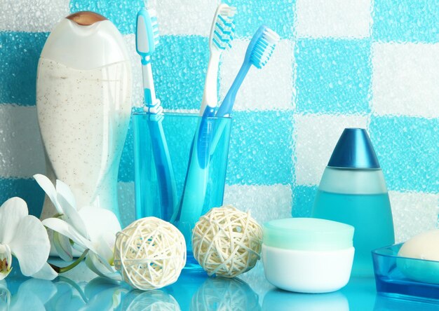 Foto accesorios de baño en el estante del baño sobre fondo de pared de azulejos azules