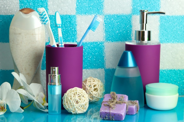 Foto accesorios de baño en la estantería del baño en la pared de azulejos azules
