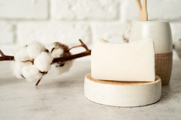 Accesorios de baño con pinceles de bambú y jabón hecho a mano en el estante del baño