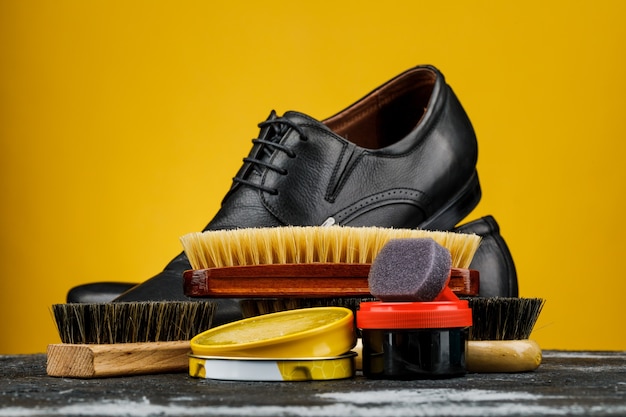 Accesorios para el cuidado y limpieza de zapatos en mesa de madera.