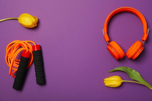 Accesorios deportivos con flores de primavera sobre un fondo púrpura