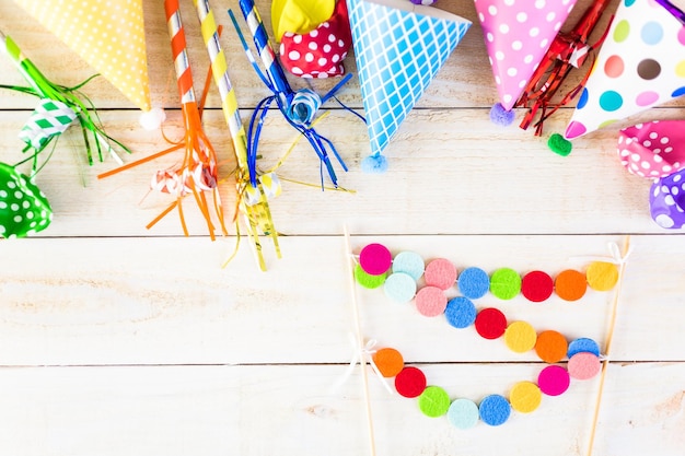 Accesorios para fiesta de cumpleaños infantil sobre un fondo de madera.