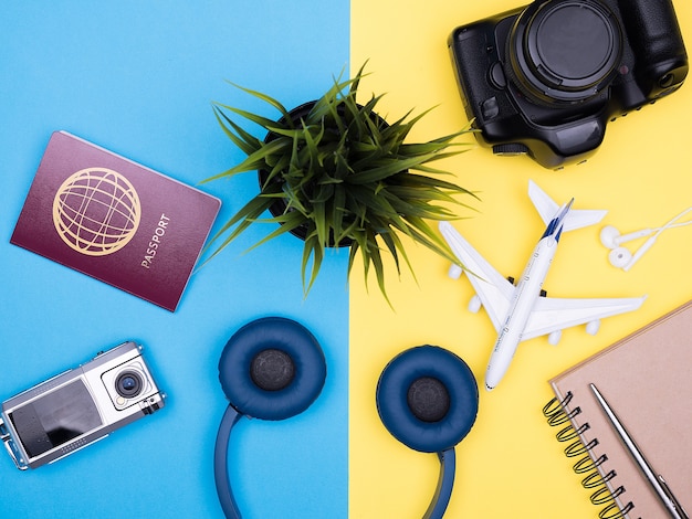 Accesorios de fotógrafo viajero plano laico sobre fondo amarillo. cámara. computadora portátil . pasaporte auriculares