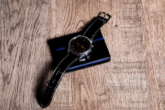 Accesorios de hombre con billetera y reloj de fondo gris.