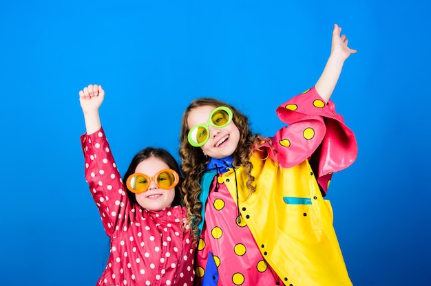 Los accesorios impermeables hacen que los días de lluvia sean alegres y agradables Moda impermeable Accesorios impermeables para niños Las hermanas felices usan una capa impermeable Disfruta del clima lluvioso con la ropa adecuada