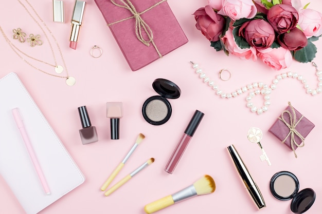 Accesorios de moda y productos de maquillaje en rosa.