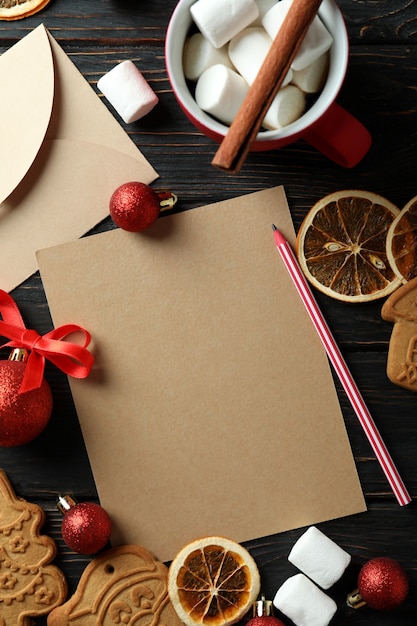 Accesorios de Navidad y lista de deseos en blanco sobre la mesa de madera, vista superior