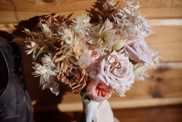 Accesorios de novios para anillos de boda zapatos corbatín y ramos de flores en la mañana