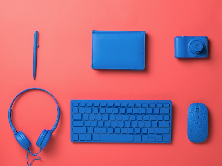 Foto accesorios de oficina y computadora azul sobre un fondo rojo. accesorios elegantes para negocios y autónomos. endecha plana.
