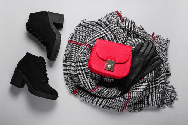 Accesorios de otoño para mujer. Bufanda femenina de moda, botas, bolso rojo, guantes. Vista superior. Lay Flat